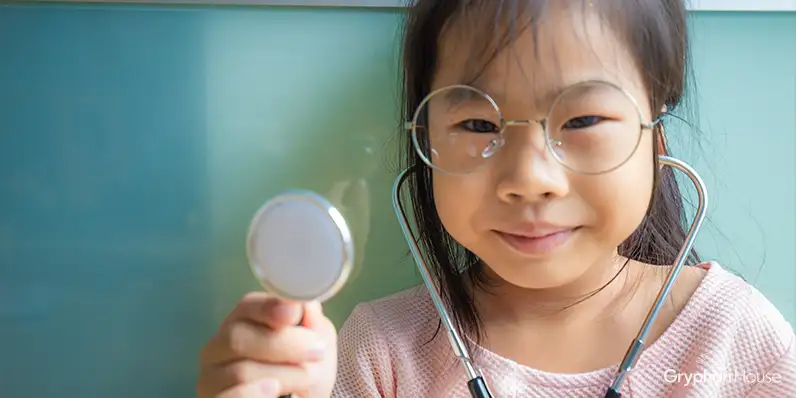 Little girl dressed as a doctor holding a stethoscope