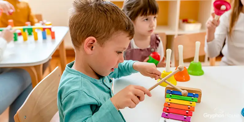 Young boy playing a colorful toy xylophone