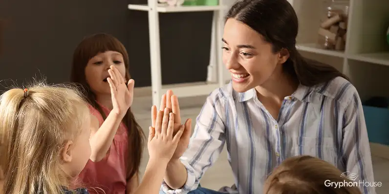 Teacher giving high five to young children