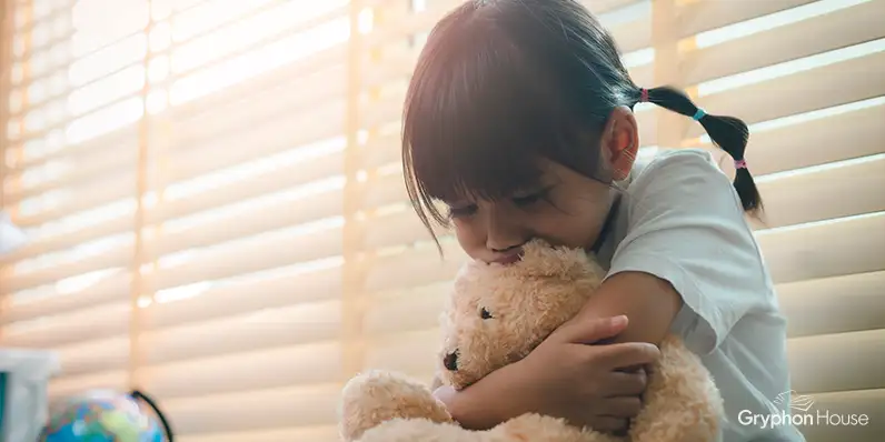 Young child hugging a teddy bear