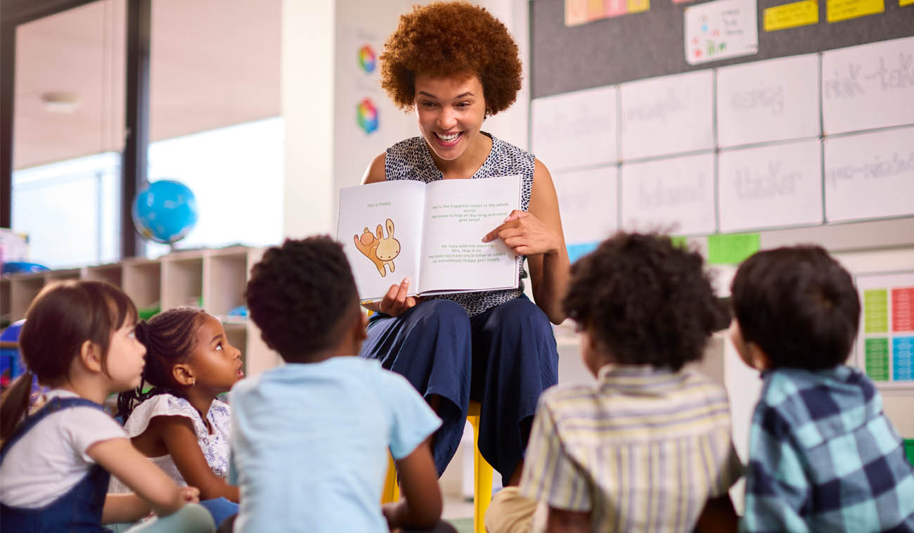 a Teacher reading to young children in a classroom